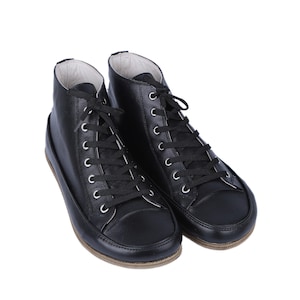 May include: A pair of black leather high-top sneakers with white laces.