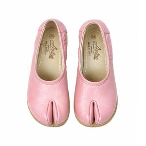 Op de afbeelding: Een paar roze leren ballerina's met een split teenontwerp. De schoenen hebben een ronde neus en een lage hak. De merknaam "Aintoo" staat op de binnenzool, samen met maat 38 en "Made in Italy".