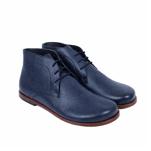 May include: A pair of navy blue leather chukka boots with a textured finish. The boots have dark laces and a brown sole. The footwear is displayed on a white background.