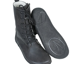 May include: Black leather ankle boots with laces and a thick sole. The boots have a zip on the inside of the ankle.