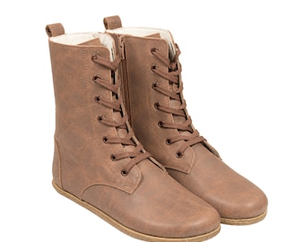 May include: A pair of mid-calf brown boots featuring a lace-up front with matching brown laces, metal eyelets, a side zipper closure, a pull tab at the heel, and a light-colored interior lining, set against a plain white background.