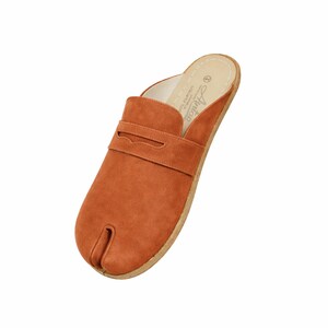 May include: A burnt orange suede slipper with a split toe design. The shoe features a strap across the top and a cork sole. The interior is white with the brand name "Auntop" printed on the insole.