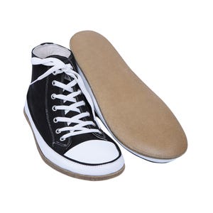 May include: Black canvas high-top sneakers with white laces and a white rubber toe cap. The shoes have a brown rubber sole.