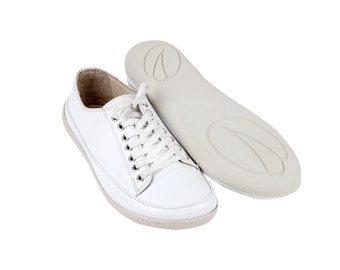 Peut inclure: Baskets basses en cuir blanc avec lacets blancs. Les chaussures ont une semelle en caoutchouc blanc et une semelle intérieure blanche.