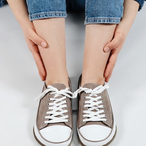 May include: A pair of gray canvas low-top sneakers with white laces and white soles.