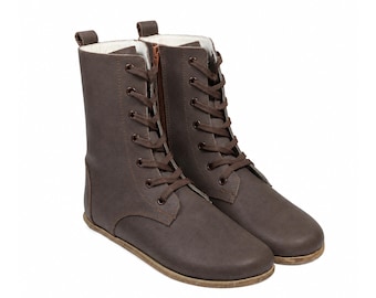 May include: A pair of mid-calf brown boots featuring a lace-up front with dark brown laces, metal eyelets, and a side zipper closure. The boots have a rounded toe, a flat sole, and a light-colored interior lining visible at the top collar.