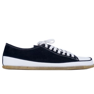 May include: A pair of black canvas low top sneakers with white laces and a white rubber sole.