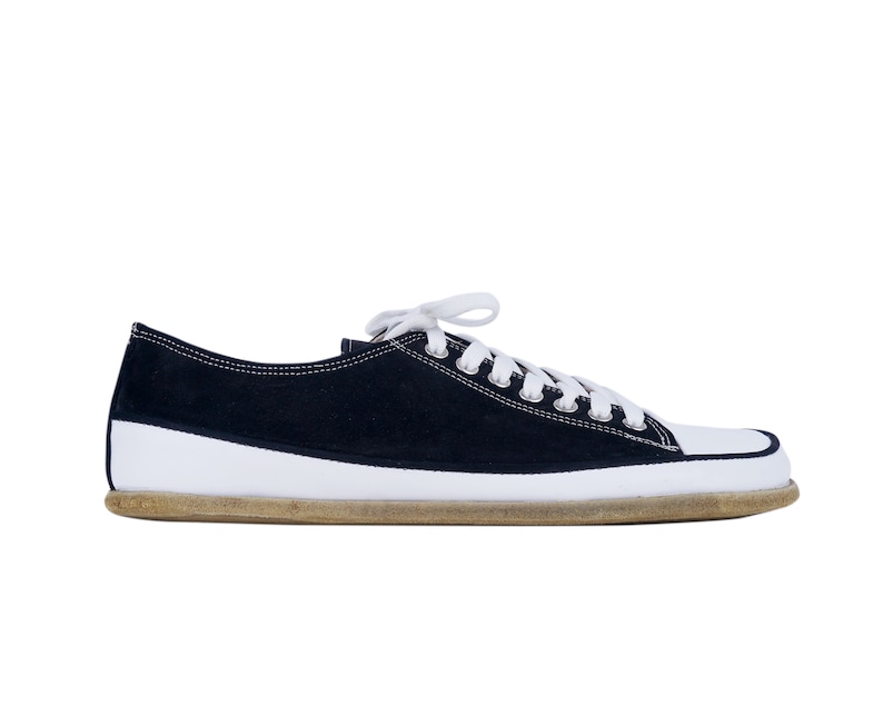 May include: A pair of black canvas low top sneakers with white laces and a white rubber sole.