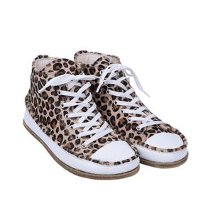 May include: A pair of leopard print high-top sneakers with white laces and white soles.