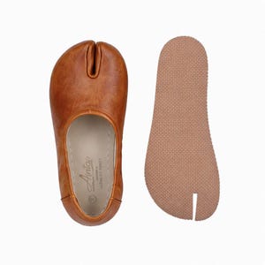 May include: A white ceramic mug with a black handle and the text "But First, Coffee" in a black, handwritten-style font. The mug is on a white surface.