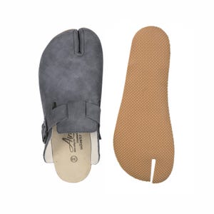 May include: Gray split-toe clog-style sandal with a buckle strap and a separate brown sole. The sandal has a textured upper and a white interior. The sole is a light brown color with a textured pattern. The sandal is size 38.