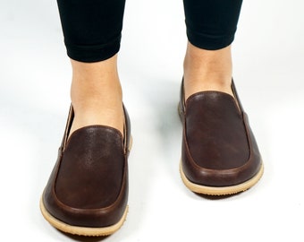 May include: A pair of brown leather slip-on shoes with a light brown rubber sole.
