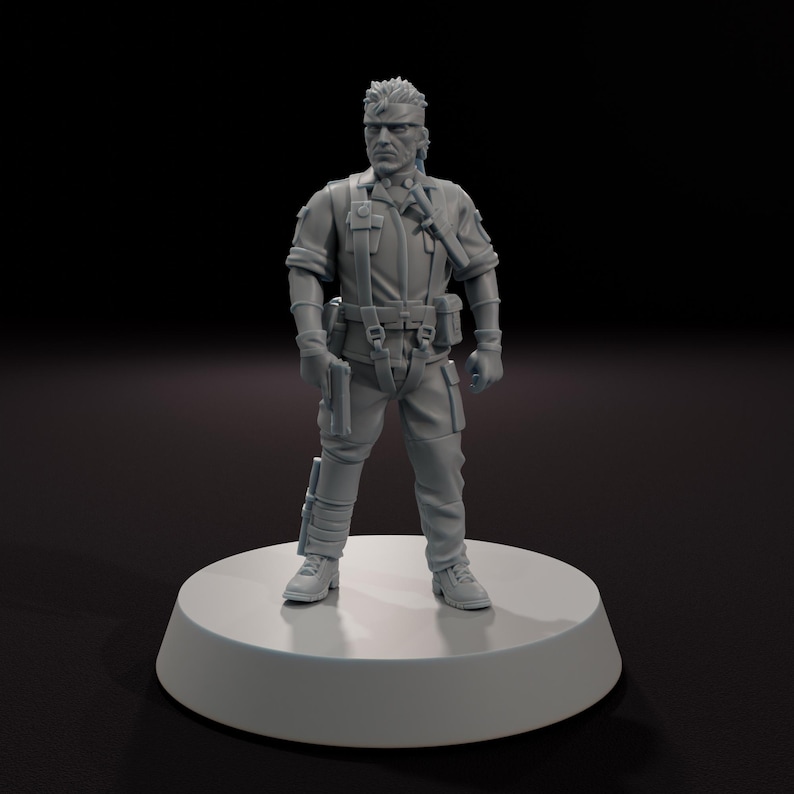 以下が含まれることがあります： 白い円形の台座に立っている、軍事スタイルの制服を着た男性の灰色のフィギュア。フィギュアは銃を持っており、頭に包帯をしています。制服には、タクティカルベスト、手袋、ブーツが含まれています。背景は黒です。