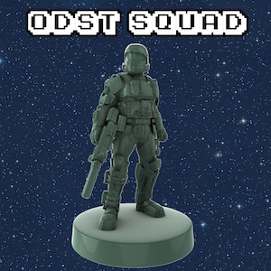 May include: A green plastic action figure of a soldier wearing a helmet and holding a gun. The figure is standing on a round base. The background is a dark blue with white stars.