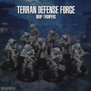 Puede incluir: Un grupo de figuras grises en miniatura de soldados con armadura futurista, cada uno con un rifle. Las figuras están sobre bases circulares negras. El texto "TERRAN DEFENSE FORCE DROP TROOPERS" está en la parte superior. La palabra "PRESUPPORTED" está abajo.