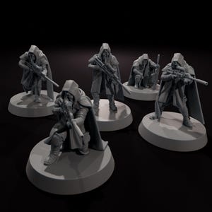 Puede incluir: Cinco figuras en miniatura grises de personajes encapuchados, cada uno sosteniendo un rifle. Las figuras están posadas en varias posturas sobre bases circulares, lo que sugiere un juego de mesa o un objeto de colección. Las figuras llevan capas y armaduras.