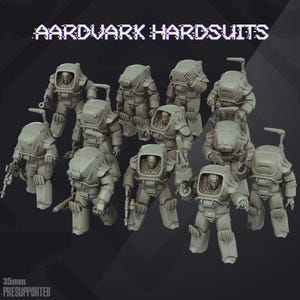 Puede incluir: Un conjunto de diez figuras en miniatura grises con trajes blindados voluminosos, etiquetadas como AARDVARK HARDSUITS y 35mm PRESUPPORTED. Cada figura presenta una cabeza con casco o expuesta dentro de una pieza pectoral gruesa y armas.