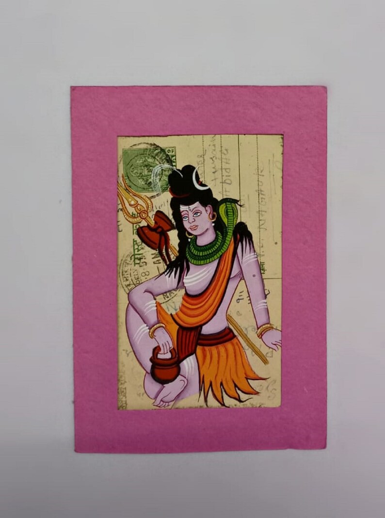 Puede incluir: Una pintura colorida de una deidad hind&uacute;, enmarcada en rosa. La obra representa una figura sentada con un tridente, vestida con ropas naranjas y amarillas, y una serpiente alrededor del cuello. El fondo parece ser papel envejecido.