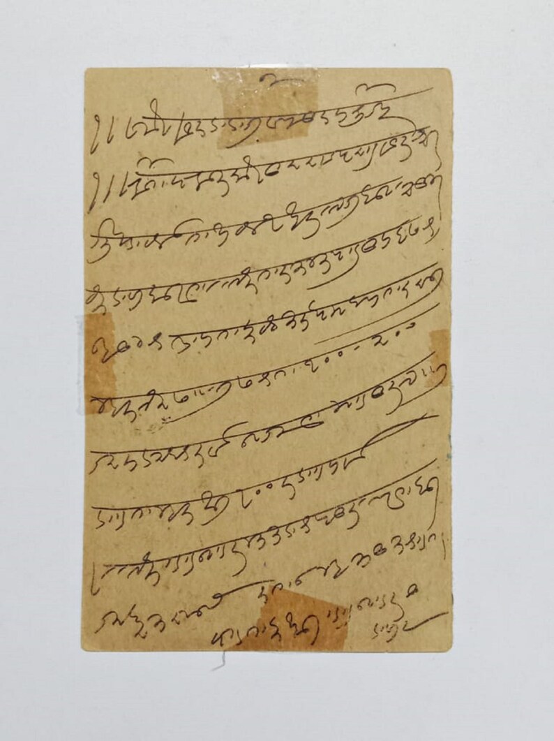 Puede incluir: Un trozo rectangular de papel envejecido con texto manuscrito en tinta negra. El papel tiene un tono marr&oacute;n claro y est&aacute; ligeramente rasgado en los bordes. La escritura parece estar en un idioma extranjero.