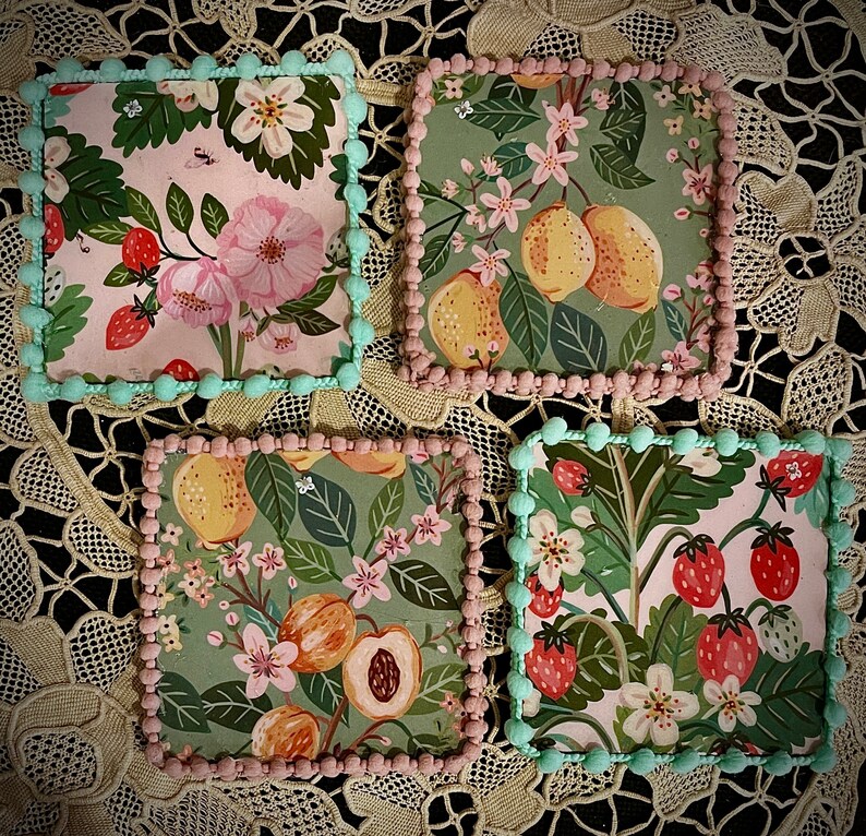 May include: Four square ceramic coasters with floral and fruit designs. The coasters feature a variety of colors, including pink, green, yellow, and blue. The designs are intricate and detailed, and the coasters are perfect for adding a touch of elegance to any home.