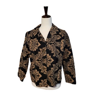 May include: A black and gold floral patterned jacket with a button closure.
