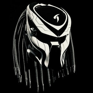 Puede incluir: Un casco de moto negro y blanco con un diseño inspirado en Predator. El casco tiene una máscara facial negra y un diseño de calavera blanca con detalles negros. El casco tiene una larga trenza negra.