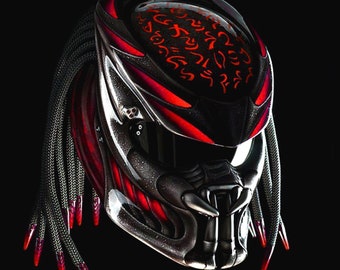 Könnte beinhalten: Ein schwarzer und roter Motorradhelm mit Predator-Design. Der Helm hat eine schwarze Basis mit roten Akzenten und ein schwarzes Visier. Der Helm hat ein schwarzes und rotes geflochtenes Band mit roten Spitzen.