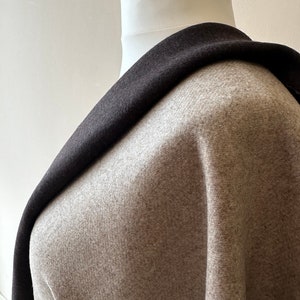 May include: A brown and black fabric with a soft, fuzzy texture. The fabric is draped over a white mannequin.