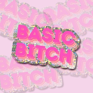 Könnte beinhalten: Rosa-weißer Aufkleber mit dem Text "BASIC BITCH" in einer Retro-Schriftart. Der Aufkleber hat eine glitzernde Oberfläche.