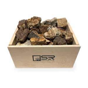 May include: A wooden box filled with brown and beige petrified wood pieces. The box has a black logo that says "SR Aquaristik" and "www.aquaristik.com".