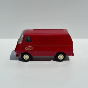 May include: A red Tonka toy van with white wheels. The van has a white label on the side that says "Tonka".