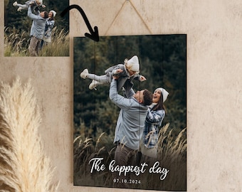 May include: A custom wooden sign with a photo of a family of three in a field. The sign has the text "The happiest day" and the date "07.10.2024" written in white script.
