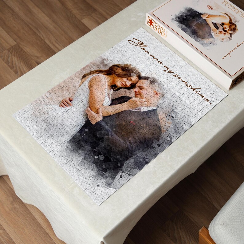 May include: A completed 500-piece jigsaw puzzle featuring a watercolor-style image of a couple embracing. The puzzle includes the text "You are my sunshine." A matching puzzle box is also visible.