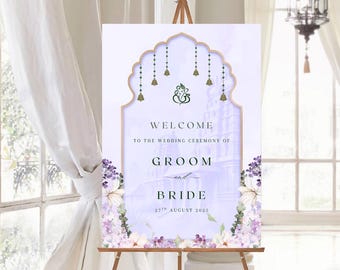 May include: A wedding welcome sign on a wooden easel. The sign has a light purple background with floral accents and the words "Welcome to the Wedding Ceremony of Groom and Bride 27th August 2025."