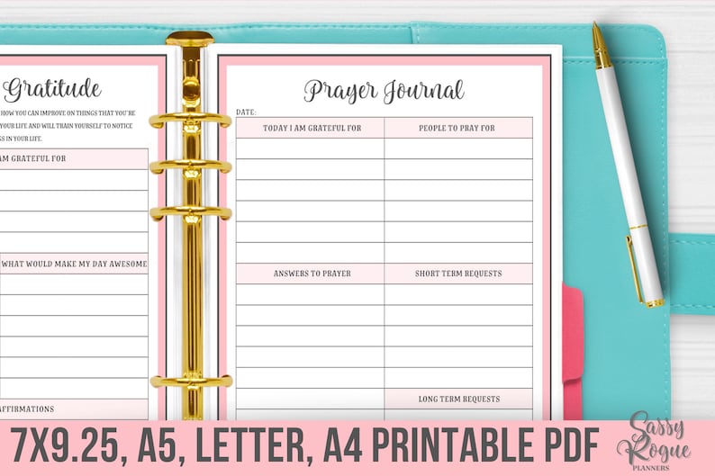 May include: A printable prayer journal and gratitude journal with pink and white pages. The journals are bound together with gold rings. The text on the cover of the prayer journal reads "Prayer Journal". The text on the cover of the gratitude journal reads "Gratitude".