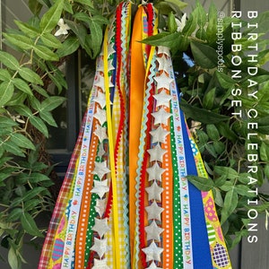 May include: A set of colorful birthday ribbon streamers with silver glitter stars. The ribbons are decorated with the text "Happy Birthday" and various patterns.
