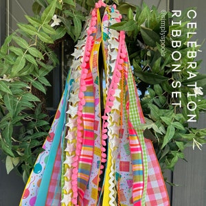 May include: A set of colorful celebration ribbons with pink pom poms, silver stars, and yellow scalloped edges. The ribbons feature various patterns, including polka dots, stripes, and a birthday cake design. The text "CELEBRATION RIBBON SET" is visible in the image.