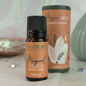 Könnte beinhalten: Eine kleine braune Glasflasche mit schwarzem Verschluss und einem Etikett mit der Aufschrift "Pure Works Perfumery Magical Vibes Lavender & Rosemary Aroma Oil".