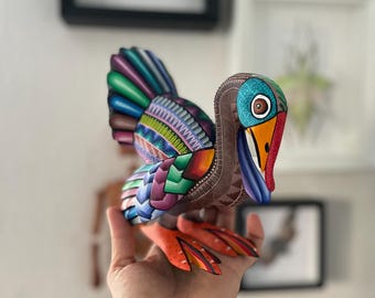 May include: A colorful, hand-painted wooden bird sculpture with intricate details. The bird has a long beak, large eyes, and a variety of colors, including blue, green, red, and yellow.