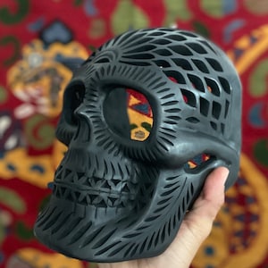 Hand carved Oaxacan black pottery barro negro calado skull with floral swirl designs from Mexico—unique piece