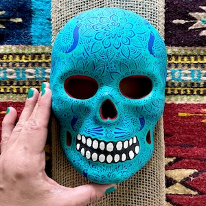 Highly detailed hand painted skull calavera with birds and flowers wall decoration from Mexico in teal and blue with red accents