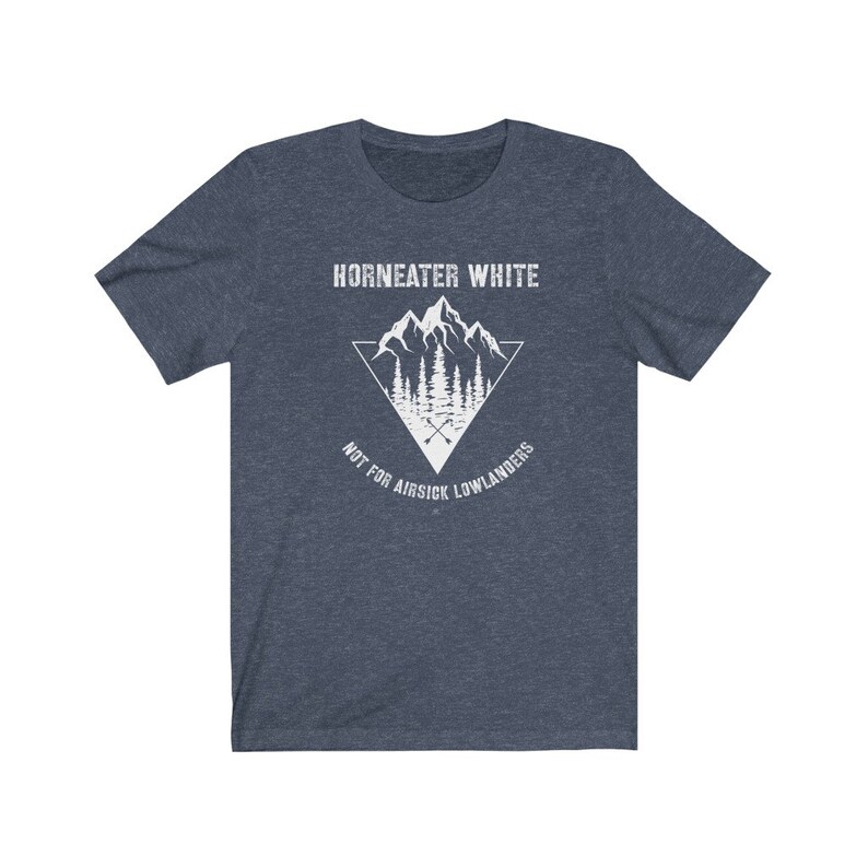 May include: A dark blue t-shirt with a white graphic design of a mountain range with a triangle around it. The text "Horneater White" is above the mountain range and the text "Not for airsick lowlanders" is below the mountain range.