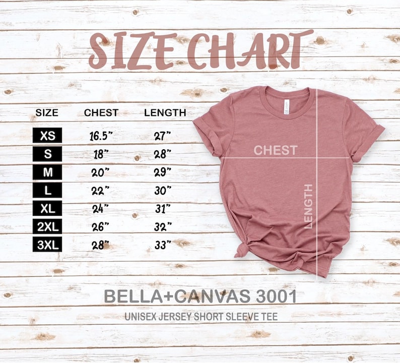 May include: Size chart for a unisex jersey short sleeve tee, showing chest and length measurements in inches for sizes XS to 3XL. The chart is printed on a light wood background with a pink t-shirt displayed next to it.