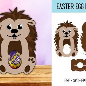 Puede incluir: Un soporte para huevos de Pascua con forma de erizo marr&oacute;n con un hueco para un huevo. El erizo tiene una cara linda con ojos grandes y una sonrisa. El soporte est&aacute; hecho de cartulina y est&aacute; listo para ser ensamblado. El texto "EASTER EGG HOLDER" est&aacute; en la parte superior de la imagen.