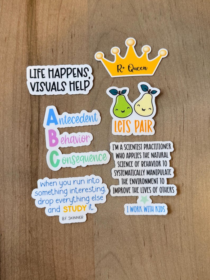 K&ouml;nnte beinhalten: Eine Sammlung bunter Aufkleber mit verschiedenen Designs und Texten. Einer der Aufkleber lautet: "LIFE HAPPENS, VISUALS HELP." Ein anderer zeigt eine goldene Krone mit "R+ Queen." Weitere Aufkleber zeigen Birnen, das ABC und Zitate &uuml;ber Verhalten und Lernen.