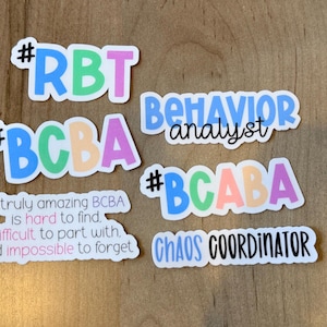 K&ouml;nnte beinhalten: Eine Sammlung farbenfroher Aufkleber mit Texten zum Thema Verhaltensanalyse. Die Aufkleber enthalten S&auml;tze wie "RBT", "BCBA", "BCABA", "Verhaltensanalytiker" und "Chaos-Koordinator". Einige Aufkleber haben zus&auml;tzlichen Text.