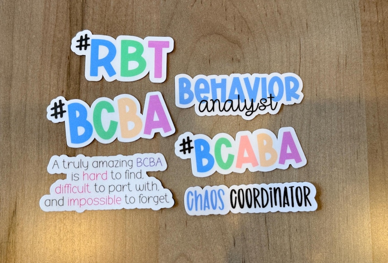 K&ouml;nnte beinhalten: Eine Sammlung farbenfroher Aufkleber mit Texten zum Thema Verhaltensanalyse. Die Aufkleber enthalten S&auml;tze wie "RBT", "BCBA", "BCABA", "Verhaltensanalytiker" und "Chaos-Koordinator". Einige Aufkleber haben zus&auml;tzlichen Text.