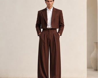 May include: A dark brown cropped blazer and matching high-waisted wide-leg trousers worn with a crisp white button-down shirt. The ensemble features clean lines and a structured fit. The text METRIC & MANOR Unlock Elegance is visible.