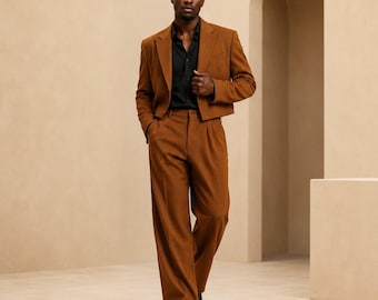 May include: A cropped tobacco brown blazer and matching wide-leg trousers worn with a black button-down shirt. The text METRIC & MANOR Unlock Elegance. is visible in the bottom left corner. The ensemble features structured shoulders and a clean finish.