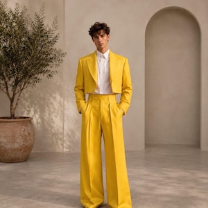 May include: A bright yellow cropped blazer with long sleeves and wide lapels, paired with matching high-waisted, wide-leg trousers. A crisp white button-down shirt is worn underneath the jacket, tucked into the trousers.